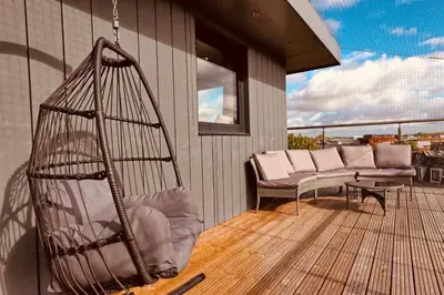 a porch with a swing on a balcony at The Opulent Property Project Penthouse Chelmsford 2 Bed 2 Bath Sleeps 6 Free Parking 2 Kings or 4 singles and Double Sofabed Ideal for long stays, corporates, families, Insurance in Chelmsford