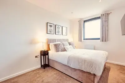 a bedroom with a bed and a window at The Opulent Property Project Penthouse Chelmsford 2 Bed 2 Bath Sleeps 6 Free Parking 2 Kings or 4 singles and Double Sofabed Ideal for long stays, corporates, families, Insurance in Chelmsford