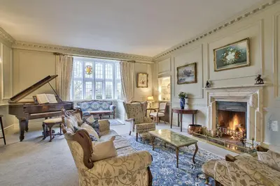 a living room with a fireplace and a piano at Holbecks House by Group Retreats in Hadleigh
