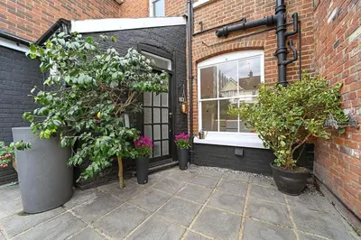 a brick building with a window and potted plants at Beautiful Home at the Heart of Colchester Great for Commuters or Professionals in Colchester