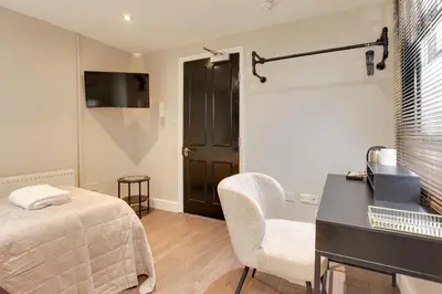 a bedroom with a bed and a desk and a chair at Cambridge City Centre by Luxiety Stays Stylish Rooms, Prime Location & Wi-Fi in Cambridge