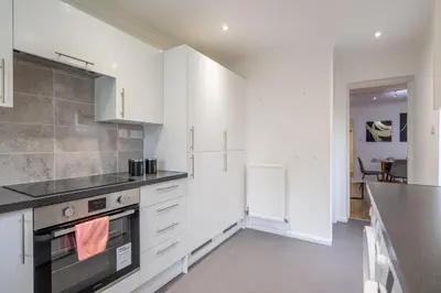 a kitchen with white cabinets and a stove at 4 BDR I sleeps 8 I Wi-FI I Free Parking I Central in Chesterton
