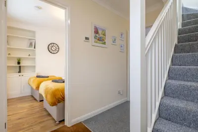 a bedroom with a bed and a staircase with a mirror at 4 BDR I sleeps 8 I Wi-FI I Free Parking I Central in Chesterton