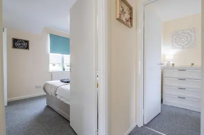 a white bedroom with a bed and a dresser at 4 BDR I sleeps 8 I Wi-FI I Free Parking I Central in Chesterton