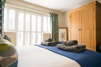 a bedroom with a bed with towels on it at Woodland Lodge, Aldeburgh in Aldeburgh