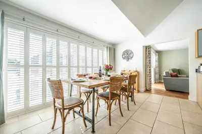 a dining room with a table and chairs at Woodland Lodge, Aldeburgh in Aldeburgh