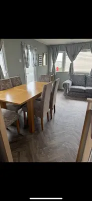 a dining room with a wooden table and chairs at Seawick Staycay in Saint Osyth