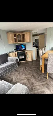 a living room with a couch and a table at Seawick Staycay in Saint Osyth