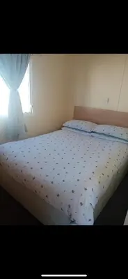 a bed in a bedroom with a window at Seawick Staycay in Saint Osyth