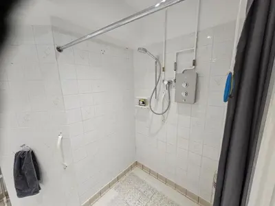 a shower in a bathroom with white tiles at Meredith House, Ipswich in Ipswich
