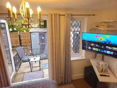 a living room with a television and a balcony at Meredith House, Ipswich in Ipswich