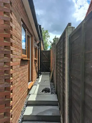a dog laying on a sidewalk next to a building at Whole Annexe in our family home & private entrance in Ipswich