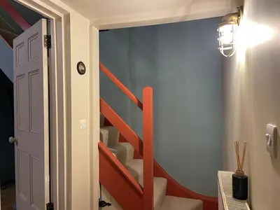 a staircase in a room with a blue wall at Pilots House Aldeburgh in Aldeburgh