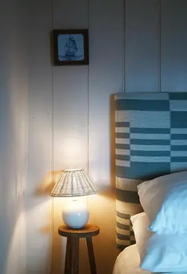 a lamp sitting on a table next to a bed at Pilots House Aldeburgh in Aldeburgh