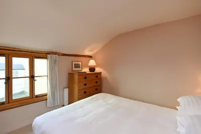 a bedroom with a white bed and a window at Pilots House Aldeburgh in Aldeburgh