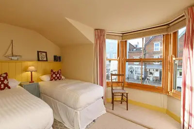 two beds in a room with a window at Pilots House Aldeburgh in Aldeburgh