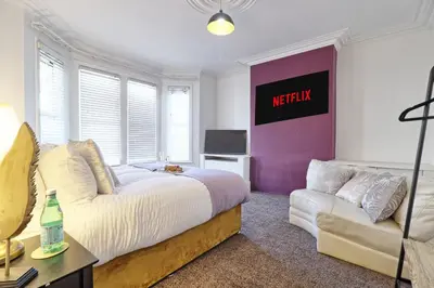 a bedroom with a bed and a couch at The Opulent Property Project Southend Beach House Sleeps 8 Free Parking x 2 Perfect for Contractors 4 King Beds or 8 Single Beds in Southend-on-Sea