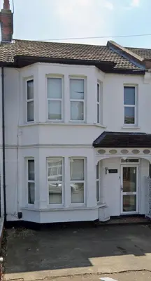 a white house with a lot of windows at The Opulent Property Project Southend Beach House Sleeps 8 Free Parking x 2 Perfect for Contractors 4 King Beds or 8 Single Beds in Southend-on-Sea
