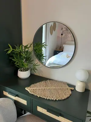 a mirror on a desk with a bed in a bedroom at Stunning and Peaceful 2 bed Flat 10 mins from Stansted Airport in Stansted Mountfitchet