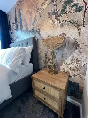 a lamp on a night stand next to a bed at Stunning and Peaceful 2 bed Flat 10 mins from Stansted Airport in Stansted Mountfitchet