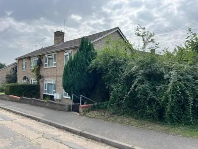 a house with a large bush growing on the side of it at Stunning and Peaceful 2 bed Flat 10 mins from Stansted Airport in Stansted Mountfitchet