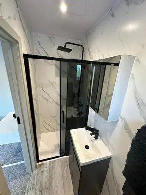 a white bathroom with a shower and a sink at Abbey House in Waltham Abbey
