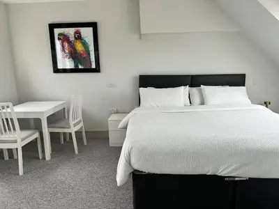 a bedroom with a bed and a table and a chair at Abbey House in Waltham Abbey