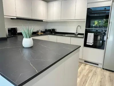 a kitchen with white cabinets and a vase on a counter at Abbey House in Waltham Abbey