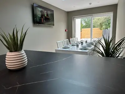 a dining room with a black table with a vase on it at Abbey House in Waltham Abbey