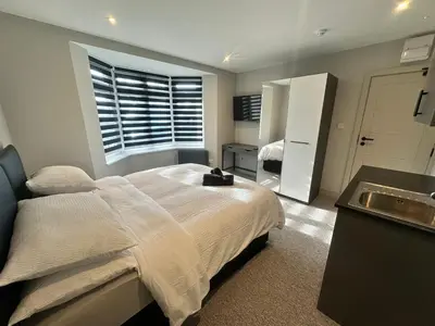 a bedroom with a bed with a sink and a window at Abbey House in Waltham Abbey