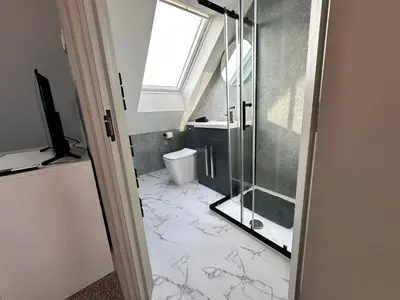 a bathroom with a glass shower and a toilet at Abbey House in Waltham Abbey