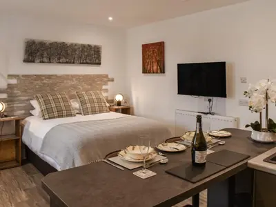 a bedroom with a bed and a table with a bottle of wine at Saddlers - Uk50519 in Ovington