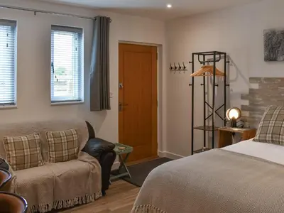 a bedroom with a bed and a chair and a door at Saddlers - Uk50519 in Ovington