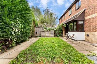 a yard with a brick building and a fence at Sleek & Stylish House in Cambridge - Sleeps 6 in Milton