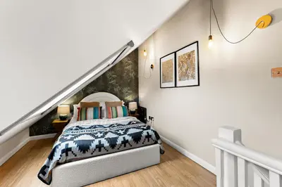 a bedroom with a bed and a staircase at Sleek & Stylish House in Cambridge - Sleeps 6 in Milton