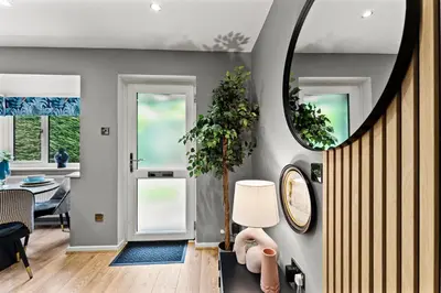 a living room with a table and a mirror at Sleek & Stylish House in Cambridge - Sleeps 6 in Milton