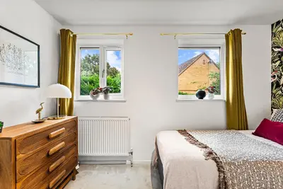 a bedroom with a bed and two windows at Sleek & Stylish House in Cambridge - Sleeps 6 in Milton