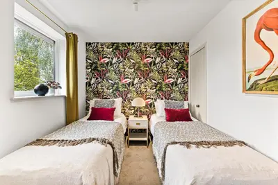 two beds in a room with a wall mural at Sleek & Stylish House in Cambridge - Sleeps 6 in Milton