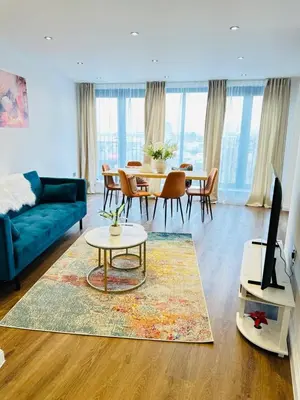 a living room with a blue couch and a table at Gorgeous two bedroom luxury Apartment sleeps 6 in Brentwood