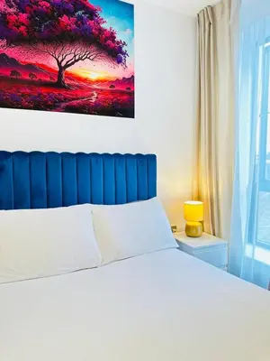 a bedroom with a bed with a painting on the wall at Gorgeous two bedroom luxury Apartment sleeps 6 in Brentwood