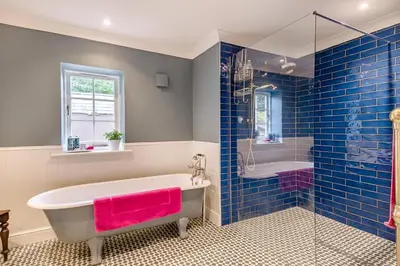 a bathroom with a tub and a shower and a sink at 1 Bed in Wymondham oc-e32664 in Wymondham