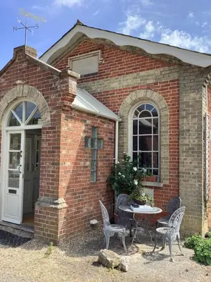 a brick house with a table and chairs outside at Basils Bolthole in Darsham