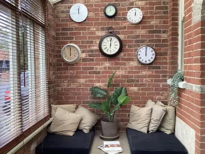 a wall with clocks on a brick wall at Basils Bolthole in Darsham