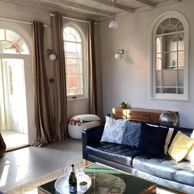 a living room with a couch and a glass table at Basils Bolthole in Darsham