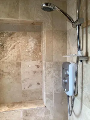 a shower with a shower head in a bathroom at Basils Bolthole in Darsham