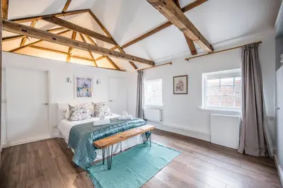 a bedroom with a bed and a table at The Loft, Bungay in Bungay
