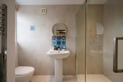 a bathroom with a toilet and a sink and a shower at The Loft, Bungay in Bungay