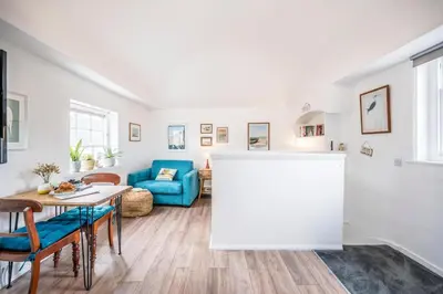 a living room with a table and a blue couch at The Loft, Bungay in Bungay