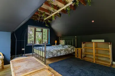 a bedroom with a bed and a blue wall at Group Stays 600-Year-Old Barn, sleeps 11 in Great Parndon