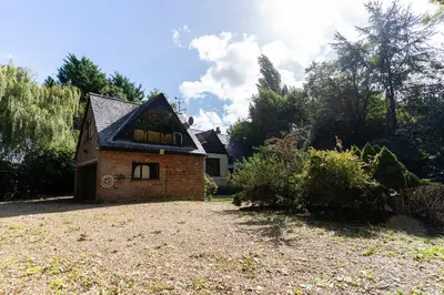 a small brick house with a roof on a yard at Group Stays 600-Year-Old Barn, sleeps 11 in Great Parndon
